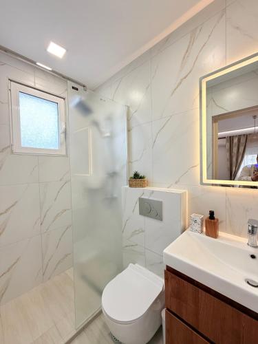 a bathroom with a toilet and a sink and a shower at Villa Sunrice in Nea Peramos