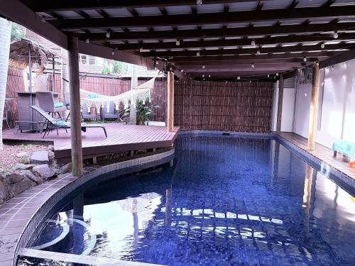 a swimming pool in a backyard with a wooden deck at Tropical Spanish Style Cabana - New Listing! in Sydney