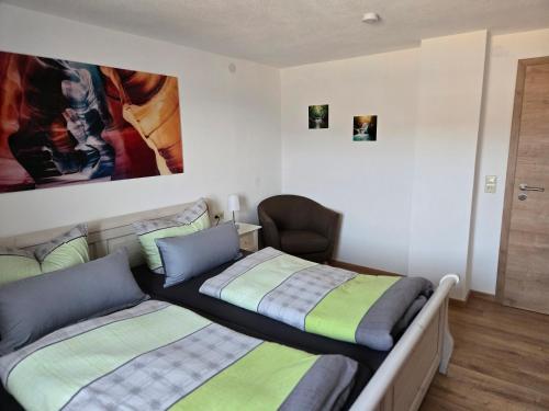 a bedroom with two beds and a chair at Binder's Ferienhaus zur Altmühl in Leutershausen