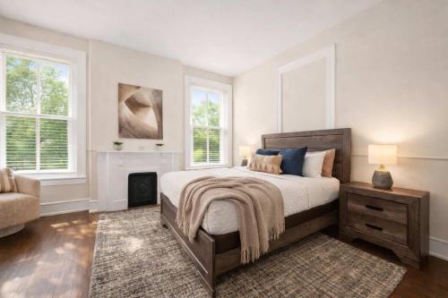 a bedroom with a bed and a fireplace and windows at Charming 7BR Home Bourbon Trail & Attractions in Louisville