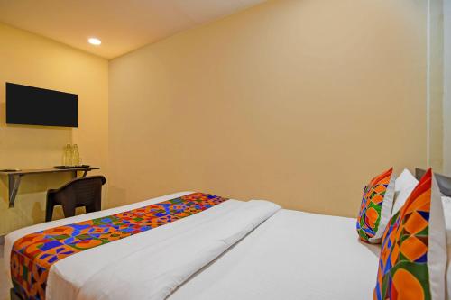 a hotel room with two beds and a tv at FabHotel The Crown Aura in kolkata