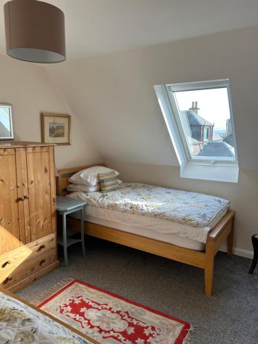 a small bedroom with a bed and a window at 2 The Old Scout Hall in Blairgowrie