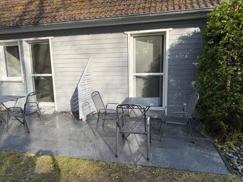a patio with chairs and a table in front of a house at Wittower Heide 40-1 in Glowe