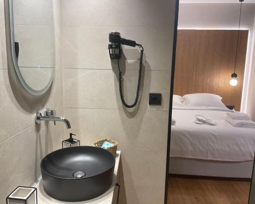 a bathroom with a black sink and a bed at Philoxenia by nature in Karkaloú