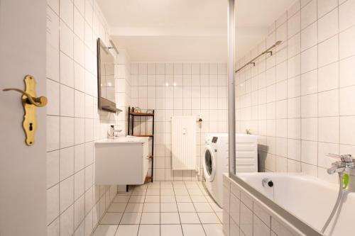 a white bathroom with a sink and a washing machine at Villa Marga Ferienwohnung Jenner in Schönau am Königssee