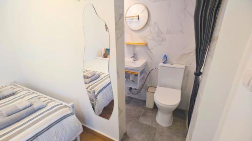 a small bathroom with a toilet and a sink at Cascais Garden House in Cascais
