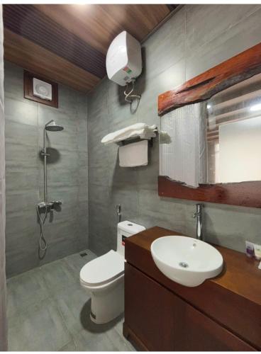 a bathroom with a toilet and a sink and a shower at Bird House Ecolodge Nghệ An in Hữu Biêt