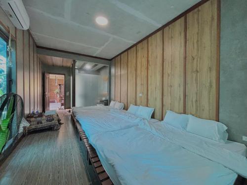 a large bed in a room with a wooden wall at Bird House Ecolodge Nghệ An in Hữu Biêt
