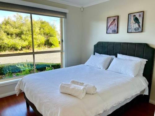 a bedroom with a large bed with two towels on it at Montrose Hilltop Garden Retreat in Rosetta