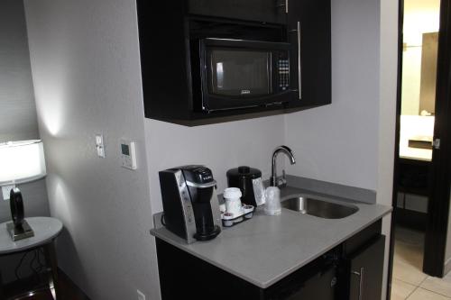 a kitchen with a sink and a microwave at Holiday Inn Express Shawnee, an IHG Hotel in Shawnee