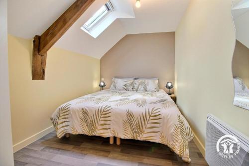 a bedroom with a bed in a attic at Du bonheur à la campagne in Mauron