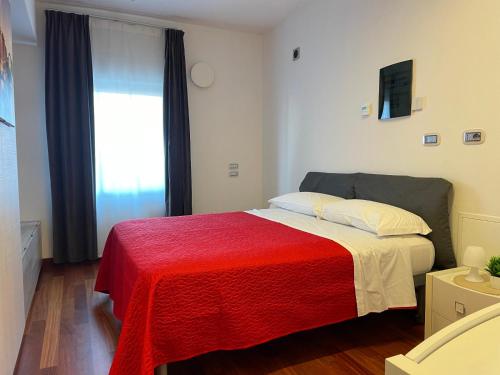 a bedroom with a bed with a red blanket at Appartamenti Ariston - Centro Giulianova in Giulianova