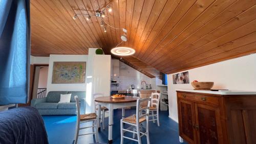 a room with a table and chairs and a kitchen at Mar Dolomiti Suite by Ca-Sa Check in San Michele