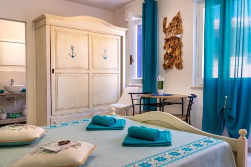 a bedroom with a bed with blue pillows on it at Affittacamere LiKele in Castelsardo