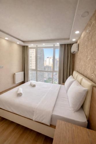 a bedroom with a large white bed with a window at dupleqs batumi daRia in Angisa