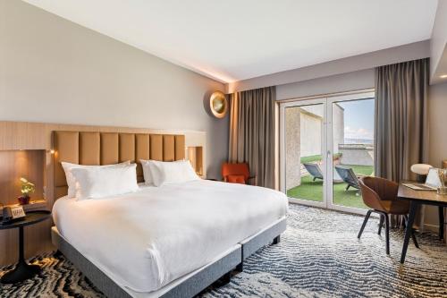 a hotel room with a bed and a desk at DoubleTree by Hilton Lyon Eurexpo & Spa in Saint-Priest