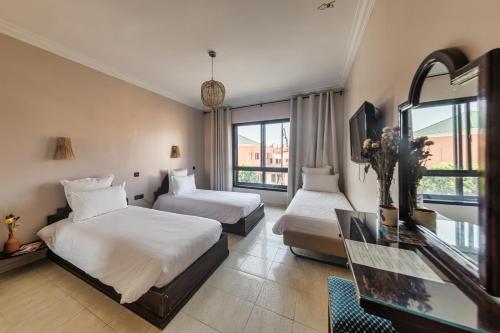 a hotel room with two beds and a window at Amani Hotel Suites & Spa in Marrakesh