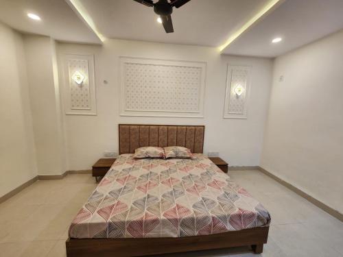 a bedroom with a bed and a ceiling fan at Omisha Stay & Pavilion in Sehore