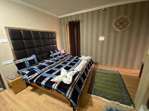 a bedroom with a large bed with a black headboard at Hotel castle rock in Pahalgām