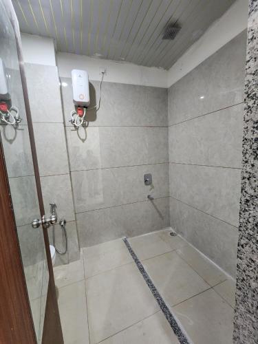 a bathroom with a shower with a camera on the wall at Omisha Stay & Pavilion in Sehore