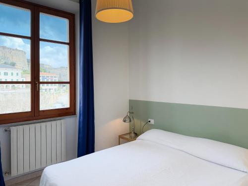 a bedroom with a white bed and a window at Ponticello Mare - HelloElba in Portoferraio
