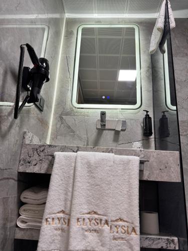 a bathroom with a sink with a mirror and towels at Elysia Plus Hotel in Istanbul