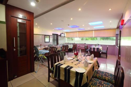 a restaurant with tables and chairs in a room at Hotel Indraprastha varkala in Varkala