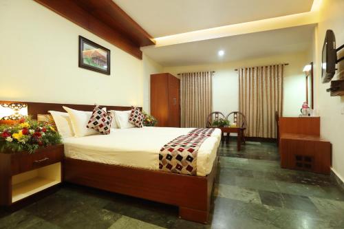a hotel room with a bed and a desk at Hotel Indraprastha varkala in Varkala