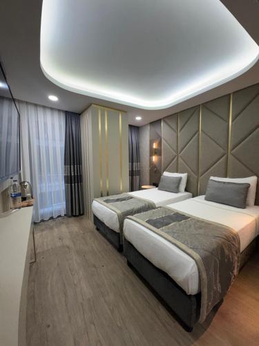 two beds in a hotel room with a large room at Elysia Plus Hotel in Istanbul