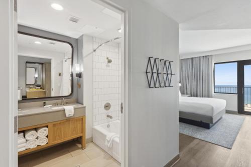 a bathroom with a bed and a sink and a tub at The Lodge at Gulf State Park, A Hilton Hotel in Gulf Shores
