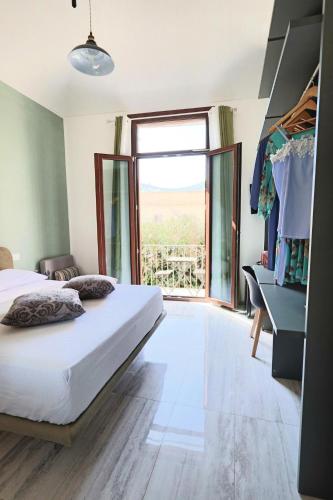 a bedroom with a bed and a large window at Agorà di Favignana - Affittacamere Piazza Madrice in Favignana