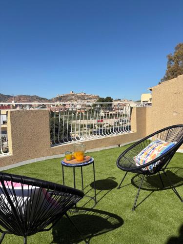 a patio with two chairs and a table with drinks on it at Apartamento en Lorca Murcia in Lorca