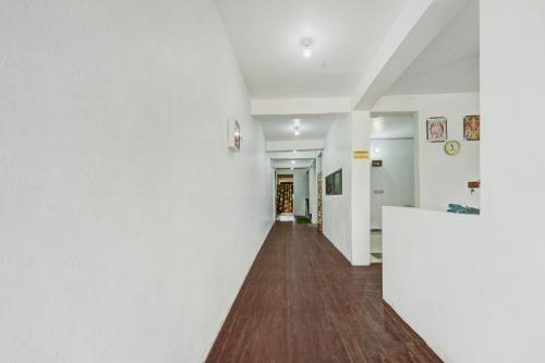 an empty hallway with white walls and wood floors at Hotel O Radha Krishna Family Hotel in Naubatpur