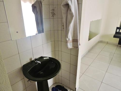 a bathroom with a black toilet and a sink at Hotel Comodoro De Livramento in Santana do Livramento