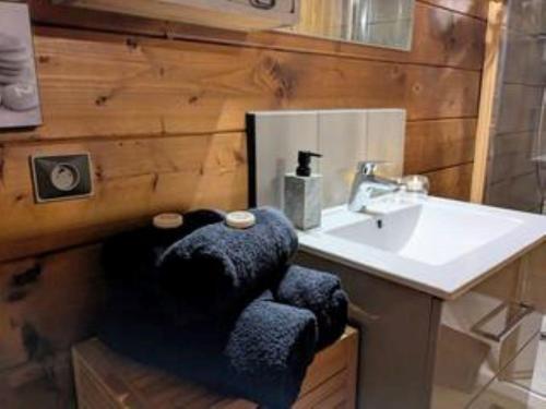 a bathroom with a sink and a blue chair at Chalet romantique avec piscine in Monthion