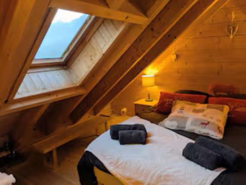 a bedroom with a large bed in a attic at Chalet romantique avec piscine in Monthion