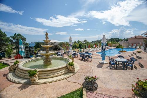 a fountain with tables and chairs next to a pool at Hotel Fiesta in Golden Sands