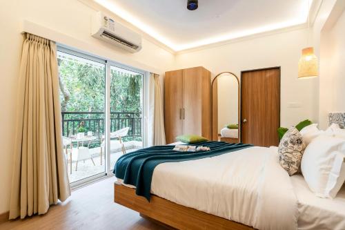 a bedroom with a large bed and a large window at Staymaster Encanto - Serviced 2BHK in Siolim