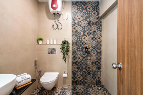 a small bathroom with a toilet and a shower at Staymaster Encanto - Serviced 2BHK in Siolim