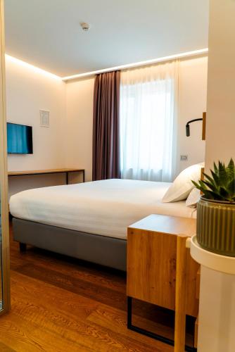 a hotel room with a large bed and a tv at GRANDI 32 Boutique Residence in Segrate