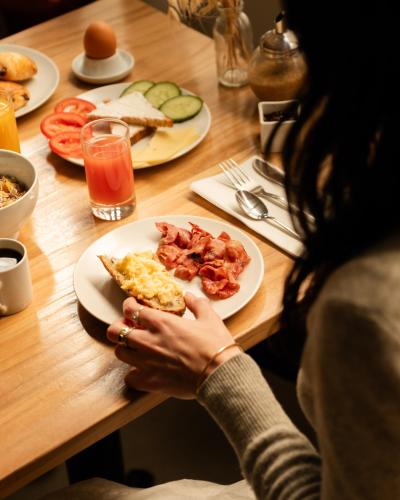 a woman sitting at a table with a plate of food at 9Hotel Bastille-Lyon in Paris