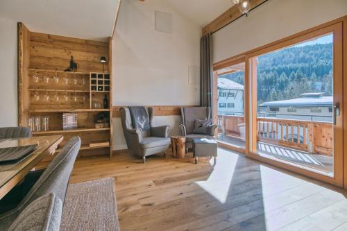 a living room with a table and chairs and a large window at Chalet Loferwinkl in Reit im Winkl