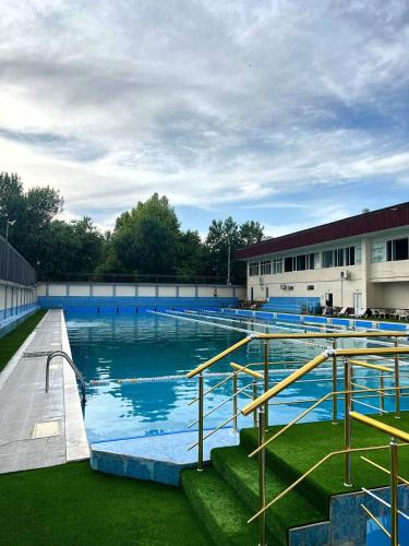 a large swimming pool in front of a building at Avenue Hotel Tashkent in Tashkent