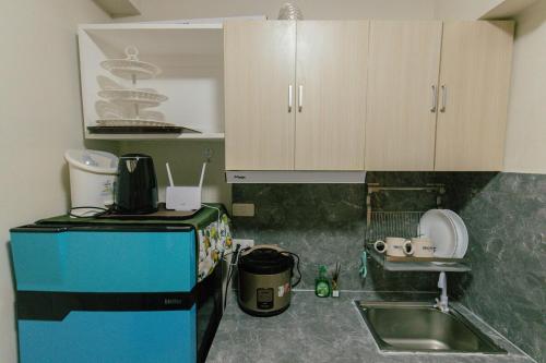 a small kitchen with a sink and a microwave at M&B Urban Haven in Suba