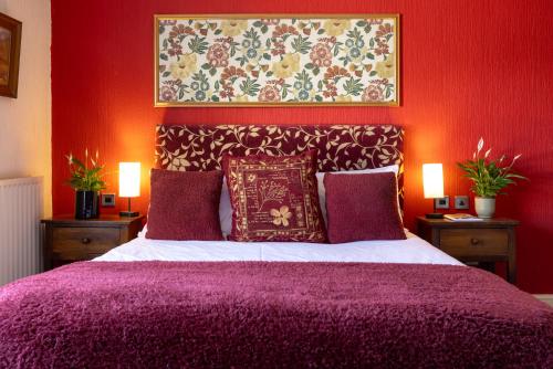 a bedroom with a bed with a purple bedspread at The bucks head in Church Stretton