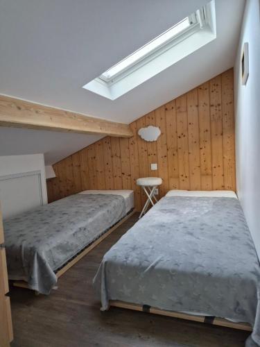 a bedroom with two beds and a skylight at Pause campagne in Fagnières