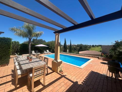 a patio with a table and a swimming pool at Perfect Golf & Beach Villa for 8 people in Estômbar