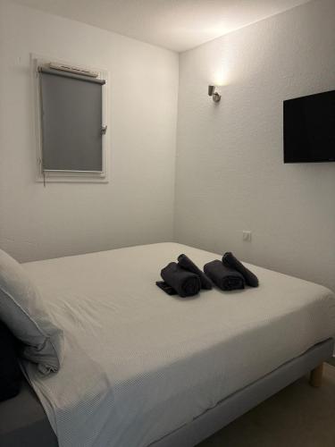una camera da letto con un letto su cui sono appoggiati due asciugamani di BEACH TROPEZ, with view a Gassin