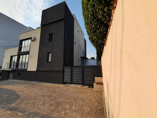 a black and white building next to a brick sidewalk at Rei 2 in Belgrade