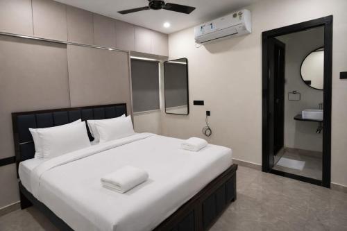 a bedroom with a large bed with white pillows at Orin Suites Gachibowli in Hyderabad
